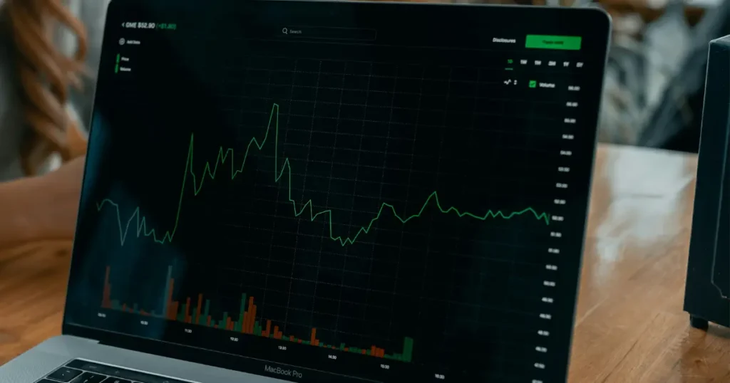 Beginner investor viewing stock market chart on laptop for first trade 2026
