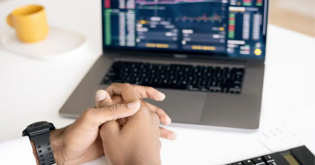 Investor analyzing stock market risk management strategy on laptop 2026
