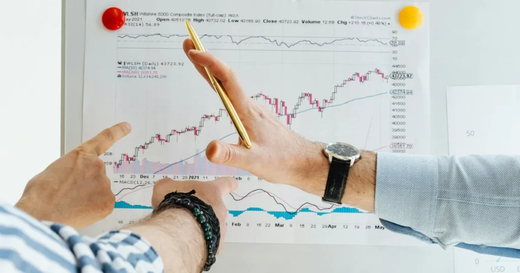 Two investors reviewing stock market chart for smart financial goals 2026
